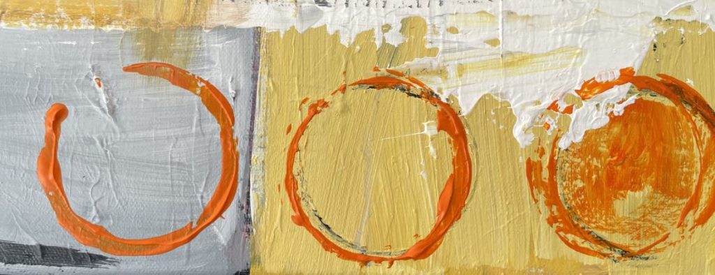 three large orange circles on a pale orange and grey background